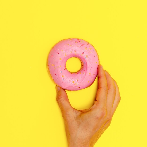 Donut doce em um fundo amarelo. Flat lay fast food art. Conceito de amante de donuts