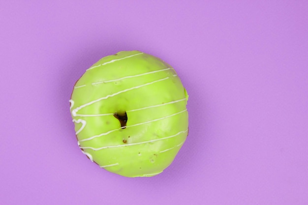 Donut dulce glaseado sobre un fondo morado Primer plano de un postre dulce Vista desde arriba