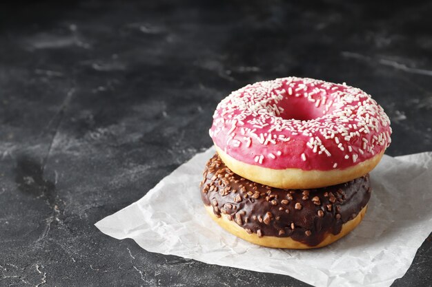 Donut dulce sabroso sobre un fondo oscuro con lugar para el texto