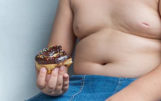 Foto donut em menino gordo obeso