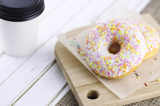 Donut em um fundo branco de madeira e vários enfeites doces