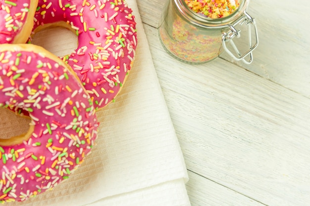 Foto donut em uma toalha de cozinha e em uma mesa de madeira. foto de doces com copyspace.