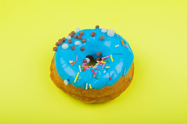 Donut con glaseado azul sobre un fondo amarillo