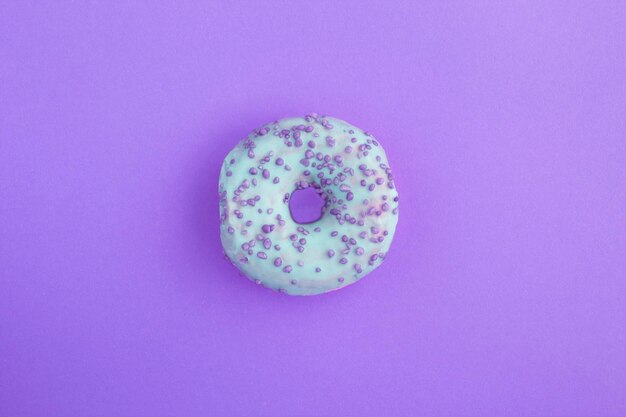 Donut con glaseado azul sobre el fondo púrpura Espacio de copia Primer plano
