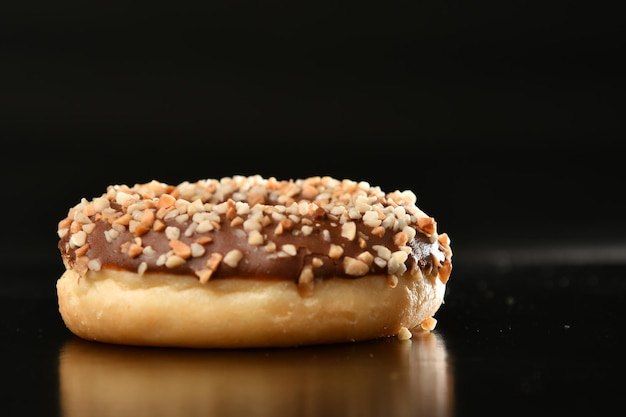 Un donut con glaseado de chocolate y chispas