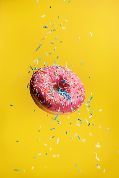 Donut levitando sobre un fondo amarillo con chispitas decorativas