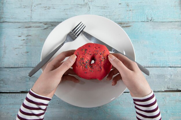 Donut de mano de mujer en placa