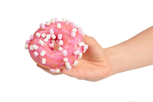 Donut rosa com marshmallow na mão da mulher isolado no branco