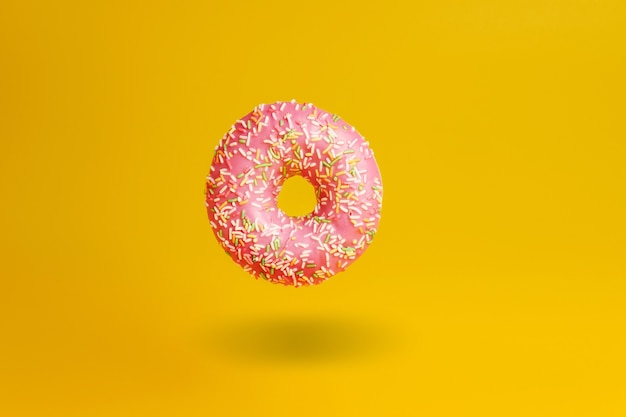 Donut rosa em amarelo com sombra