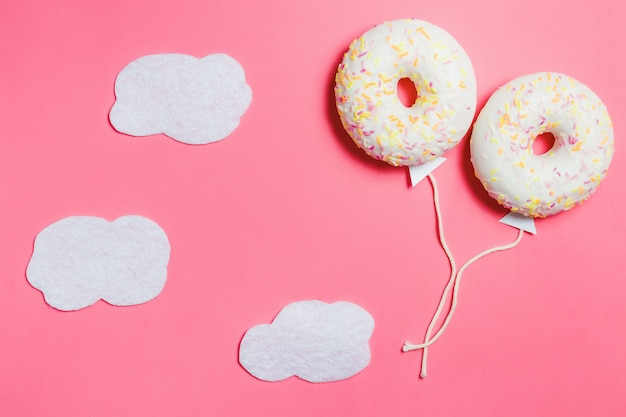 Donut en rosa, minimalismo creativo de alimentos, Donut en forma de globo en el cielo con nubes, vista superior con espacio de copia, tonificado