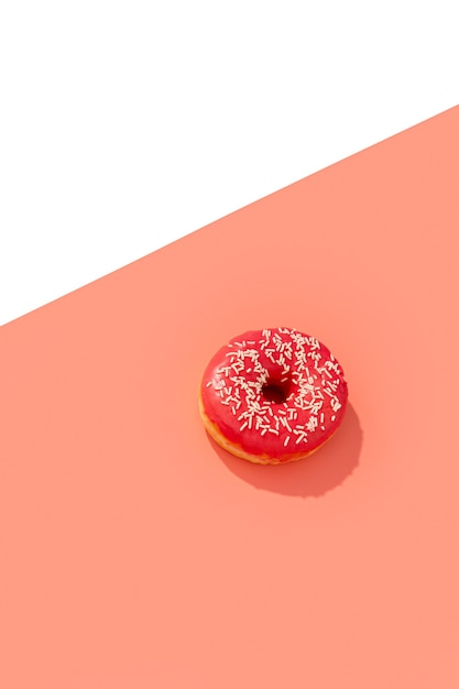 Donut rosa sabroso en creativo con sombra larga y profunda