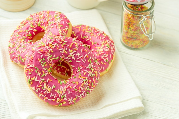 Donut sobre una toalla de cocina y sobre una mesa de madera. Foto de dulces.