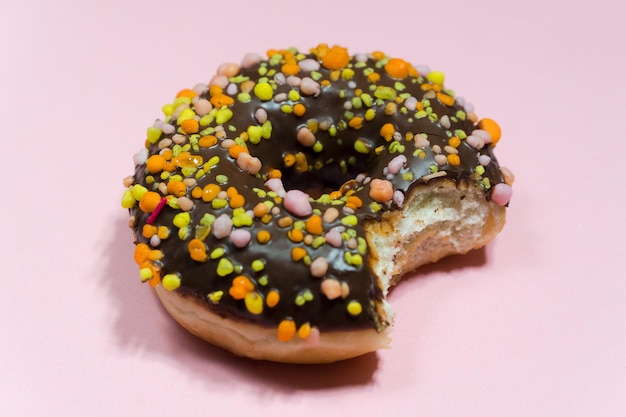 Donut tradicional estadounidense con chispas sobre un fondo contrastante.