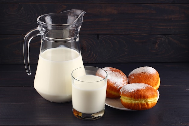 Donut und Milch auf dunklen Brettern