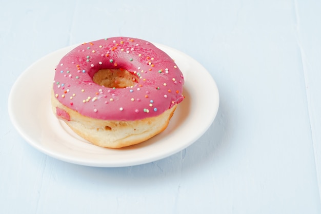 Donut vitrificado com granulado no prato vista de cima