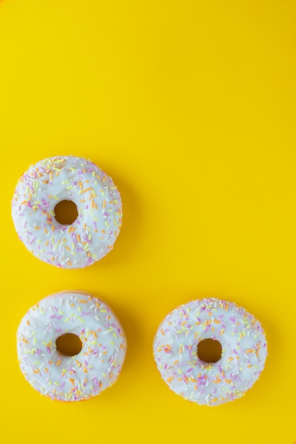 Donuts blancos con fondo amarillo Donuts con chispas