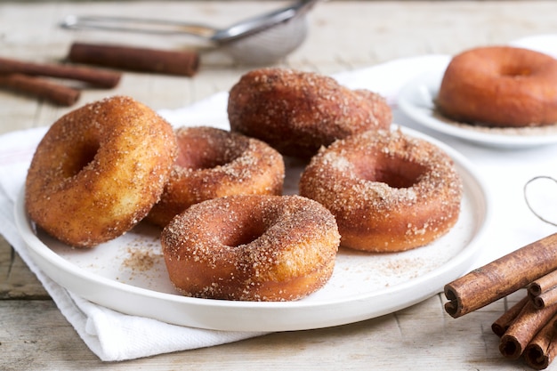 Donuts caseros con azúcar y canela sobre un fondo de madera. Estilo rústico