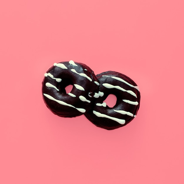 Donuts de chocolate sobre fondo rosa vainilla