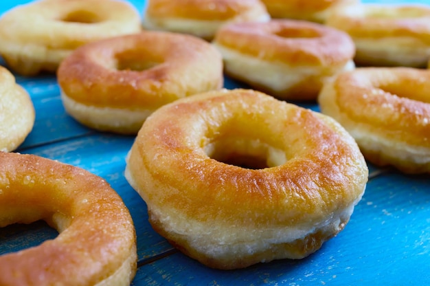 Donuts clásicos caseros sobre una mesa de madera azul. De cerca.