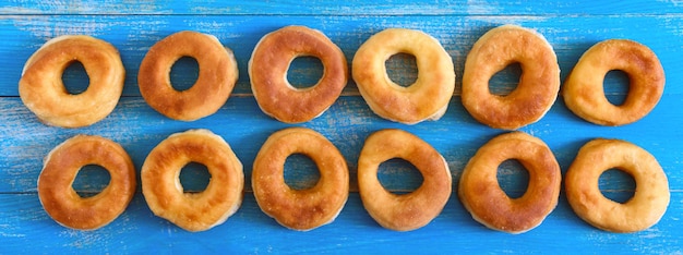 Donuts clásicos caseros sobre una mesa de madera azul. La vista superior. Fondo de alimentos. Bandera.