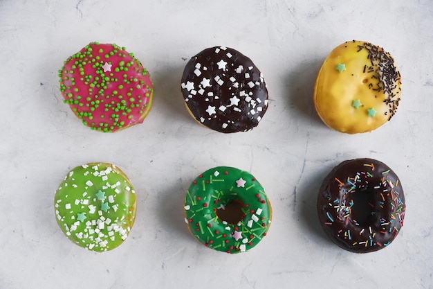 Donuts coloridos caseros en mesa blanca