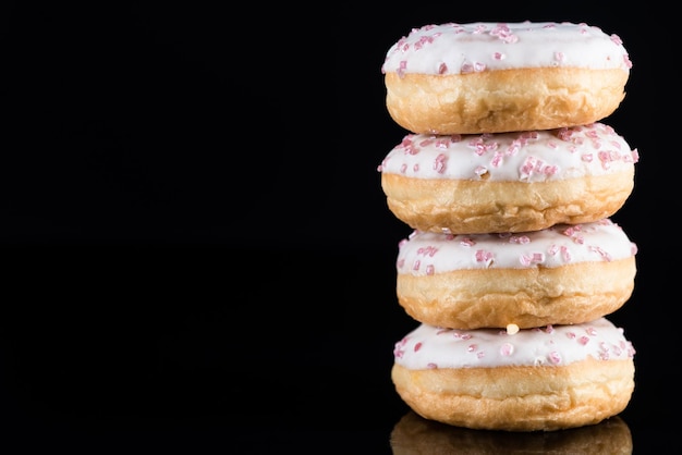 Donuts de chocolate branco ou torre de donuts em fundo escuro