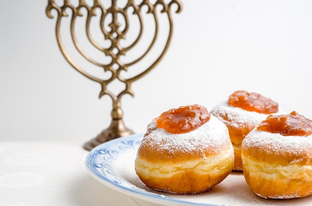 Foto donuts de hanukkah minor com geléia em um prato sobre um fundo branco