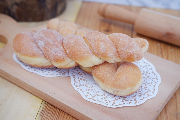 Donuts de pão na mesa de madeira com rolo de madeira