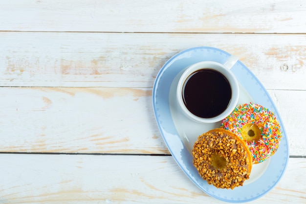 Donuts e café em um fundo branco de madeira