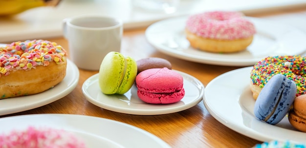 Donuts e macarons na madeira vista de perto com detalhes