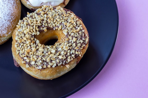 Donuts em placa preta e fundo rosa