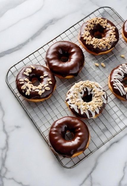 Foto donuts esmaltados de chocolate cobertos de nozes picadas em uma prateleira de resfriamento de arame com um mármore branco