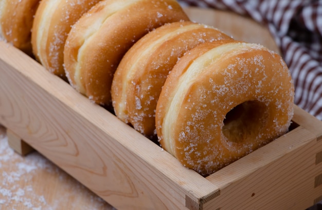 Donuts están arreglando en la caja de madera