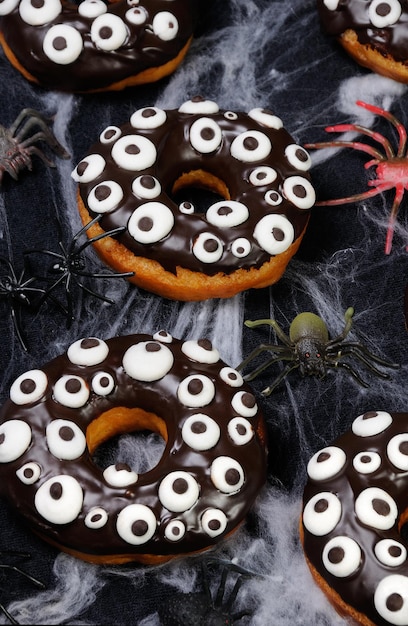 Donuts con glaseado de chocolate decorados con ojos saltones en Halloween