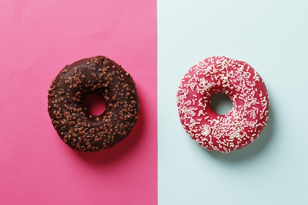 Donuts con glaseado sobre fondo rosa. Rosquillas dulces. Fondo de donas. Donut comido.