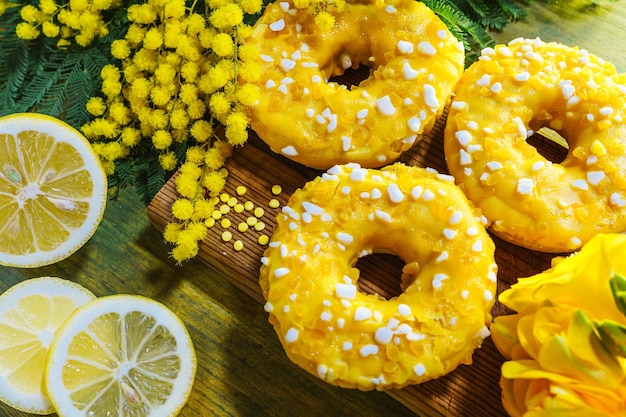Donuts de limón caseros con chispas sobre fondo de madera.