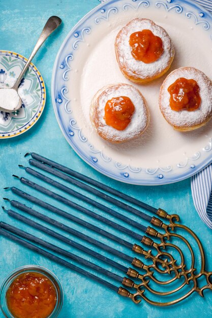 Donuts con mermelada de albaricoque en un plato de cerámica y chanukia