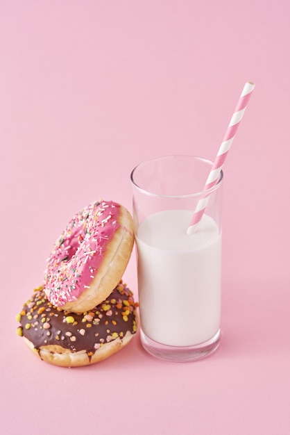 Donuts mit einem Glas Milch auf rosa