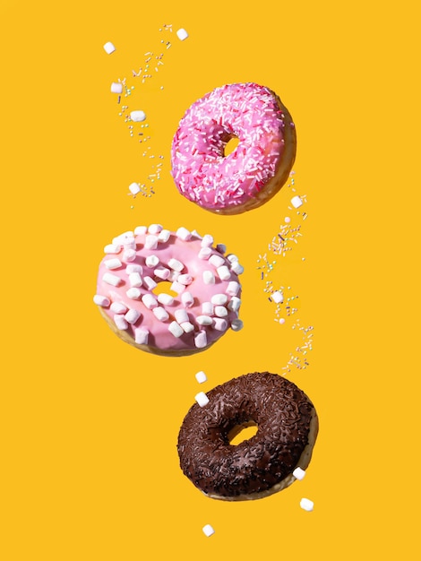 Donuts mit Streuseln auf gelbem Grund. Levitation von Donuts