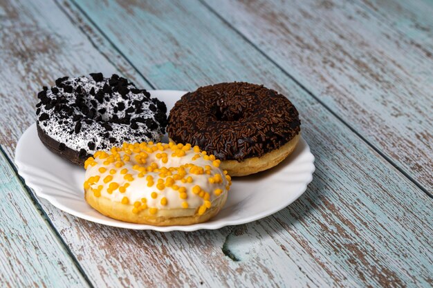 Donuts en un plato blanco sobre una mesa de madera