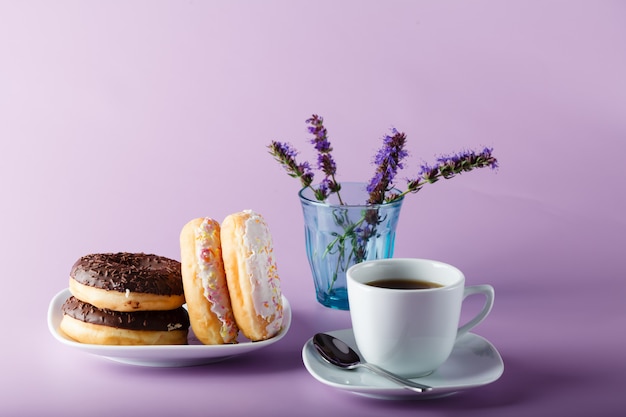 Donuts en plato con taza y flores