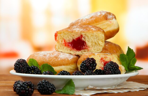 Donuts saborosos com bagas em mesa de madeira