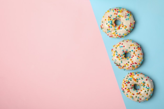 Donuts sabrosos sobre fondo de dos tonos, vista superior