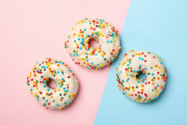 Donuts sabrosos sobre fondo de dos tonos