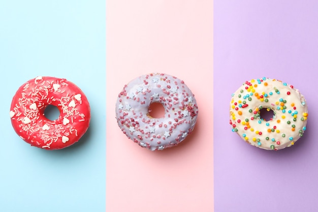 Donuts sabrosos sobre fondo de tres tonos