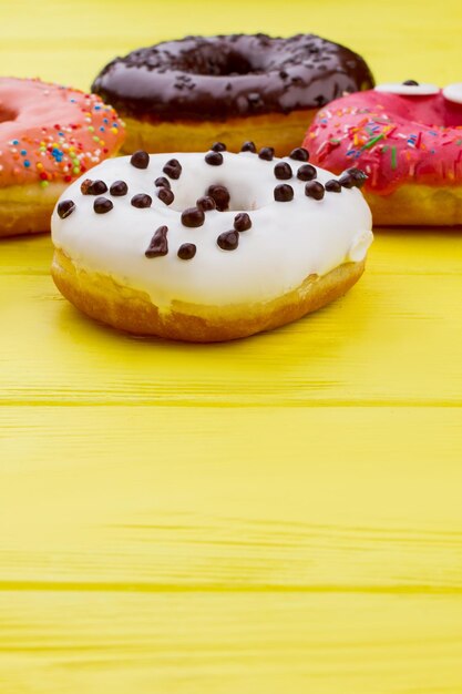 Foto donuts sobre fondo de madera de color con espacio de copia. pasteles redondos glaseados. deliciosos dulces con glaseado.