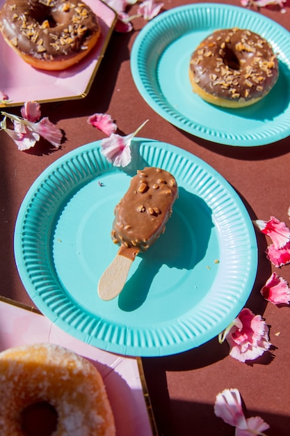 Donuts und Eis auf Tellern mit Dianthusblättern