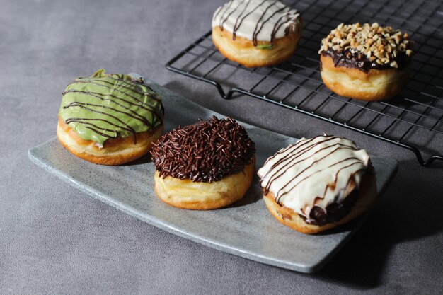 Foto donuts variados dispostos em uma bandeja fotografia darkmood