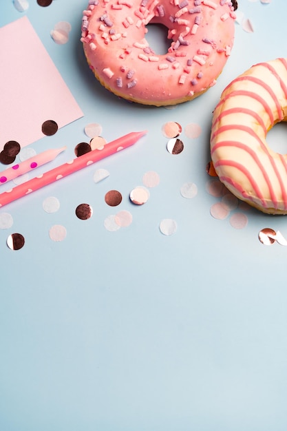 Foto donuts velas confeti fondo rosa y azul para fiesta de cumpleaños