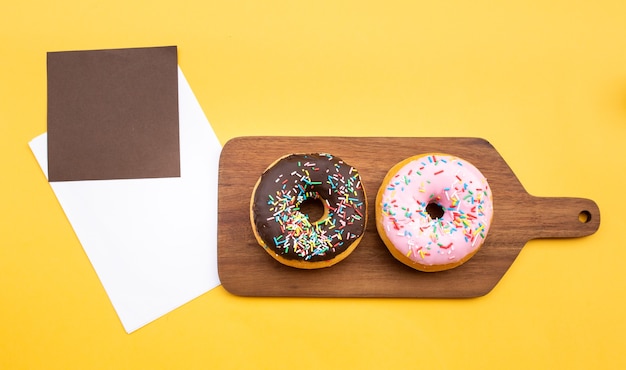 Foto donuts de vista superior con sobre acompañado de leche